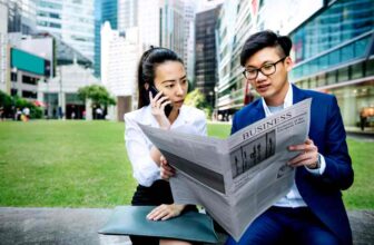 Two person reading anews paper in a park!